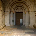 Arched Entrance Gate with Stone Walls Stone Columns Wooden Door and Slab Floor