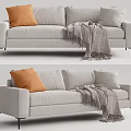 Light Gray Two Seater Sofa Featuring Orange Cushion Gray Fringe Blanket And Black Slim Legs