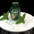 Medical Device Green Bottle With White Tablets And Fresh Leaves On Marble Table