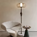 Modern Floor Lamp With Brass Base And Glass Shade Beside Cozy Chair And Side Table