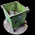 Green Trash Bin With Wheels Filled With Plastic Bottles And Waste On Ground