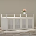 White Kitchen Island Cabinet With Glass Doors And Vase Of Pink Flowers On Wooden Floor
