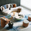 Curved Light Colored Sofa with Cushions and Round Coffee Table Set on Blue Patterned Rug 3d model