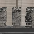 Three Traditional Stone Pillars With Intricate Dragon Head Carvings And Bamboo Blinds Background