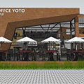 Coffee YOTO Storefront With Brick Building Large Glass Windows Outdoor Seating White Umbrellas And Greenery