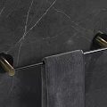 Bathroom Towel Rod with Black Metal and Gold Base Hanging Gray Towel on Marble Wall