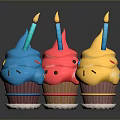 Colorful Cupcakes with Pink Blue Yellow Frosting Lit Candles and Sprinkles on Shiny Black Background