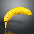 Ripe Yellow Banana with Black Spots Isolated on Dark Background with Reflection