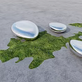 Silver Pebble Shaped Landscape Seats On Gray Concrete With Green Grass Patches