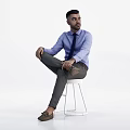 Group of people wearing blue shirts and dark ties sitting on white stools