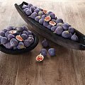 Fresh Ripe Pomegranates With Sliced Sections And Arils In Black Bowls On Wooden Table