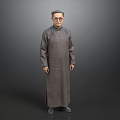 Full Length Portrait of Man in Traditional Gray Robe Standing Against Gray Background with Glasses