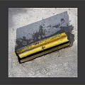 Yellow Road Barrier With Graffiti Featuring BOBA Text And Symbol On Concrete Ground