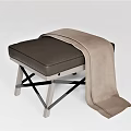 Modern Ottoman With Soft Brown Cushion And Wooden Legs Topped With Cozy Blanket
