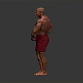 Muscular Man Posing to Showcase Well Developed Muscles in Red Shorts
