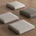 Soft Square Floor Cushions In Light And Dark Gray Tones On Wooden Surface