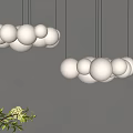 Modern Hanging Chandelier With Multiple White Spherical Balls And Green Plant On Gray Wall