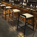 Row of Wooden Bar Stools With White Cushions At Modern Bar Counter