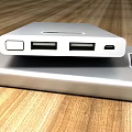 Silver Mobile Power Banks With USB Ports And Digital Displays On Wooden Tabletop