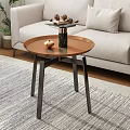 Round Copper Top Coffee Table With Black Metal Legs On Striped Rug And Decorative Items