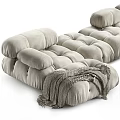 Light Beige Irregular Shaped Sofa With Plush Velvet Tufted Design And Knitted Blanket