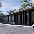 Modern Sales Office Building Featuring Glass Curtain Walls Gray Stone Green Plants And Lawn Entrance