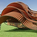 Wave Shaped Wooden Architectural Structure On Green Grass Under Blue Sky 3d model
