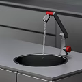 Modern Kitchen Faucet With Red Handles And Black Sink Running Water On Gray Countertop