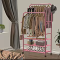 Pink Clothing Rack with Hanging Clothes Hats Books Boxes and Shoes in Bedroom