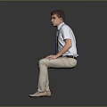 Man Sitting On Dark Surface Wearing Light Blue Shirt Striped Tie And Khaki Pants