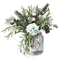Elegant Decorative Flower Arrangement In Transparent Glass Vase With White Flowers And Green Leaves