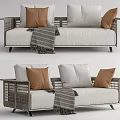 Rattan Frame Outdoor Sofa With White Cushions Brown Pillows And Striped Throw