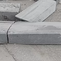Broken Concrete Blocks Scattered On Ground With Cracks And Metal Fasteners
