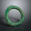 Green Circular Bronze Sculpture Featuring Intricate Decorative Carvings On Surface