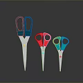 Three Different Colored Scissors with Metal Blades and Colored Handles on Dark Background