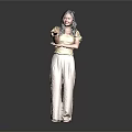 Woman in yellow top and beige pants standing with crossed arms against dark background