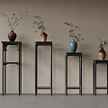 Black Flower Stands With Vases And Plants Against Light Colored Wall And Gray Floor