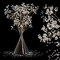 Transparent Cone Shaped Vase with White Flowers and Scattered Small Blooms on Black Background