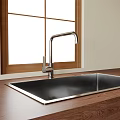 Stainless Steel Kitchen Sink With Modern Faucet On Wooden Countertop By Window