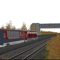 Scenic Train On Railroad Tracks With Blue Sky White Clouds Gate Building And Yellow Foliage
