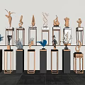 Black And Gold Pedestals Displaying Various Metal Sculptures With Artistic Designs