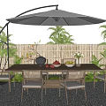 Outdoor Dining Table With Rattan Chairs Umbrella Plants Bamboo Fence And Fruit Bowl