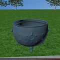 Gray Fireplace Cauldron With Three Legs And Side Handles On Green Grass With Trees