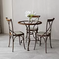 Round Wooden Dining Table With Cross Back Chairs And White Flower Vase In Modern Interior