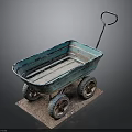 Blue Vintage Wheelbarrow with Four Rustic Wheels on Brown Mat Against Dark Background