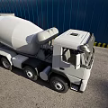 Gray Concrete Mixer Truck Parked At Industrial Construction Site With Blue Wall