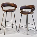 Two Brown Leather Bar Stools With Curved Backrest And Modern Metal Legs Design