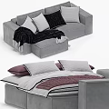 Modern Gray Sofa With Pillows And Blanket And Comfortable Bed With Purple Quilt