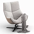 Modern Lounge Chair With Gray Cushion Beige Frame Black Base And Knitted Blanket
