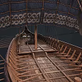 Ancient Wooden Boat With Blue Decorated Sail And Traditional Wooden Oars Structure